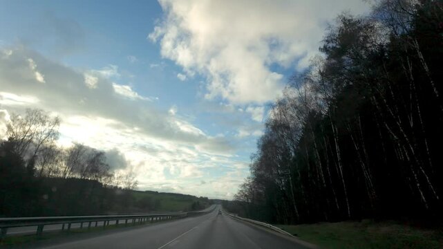 Cinematic POV Driving on a Scenic Countryside Highway Under a Dramatic Cloudy Sky