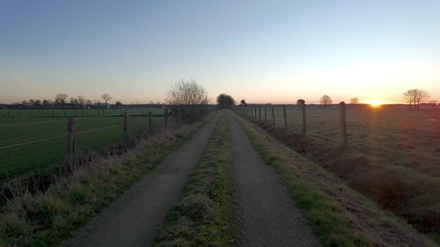 Cinematic Reverse Motion on a Rural Dirt Path During a Beautiful Golden Hour Sunset or Sunrise