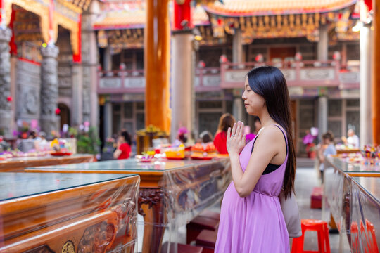 Pregnant woman praying inside temple in taiwan