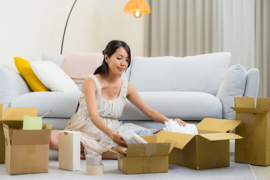 Pregnant woman preparing cardboard box
