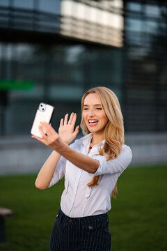 Woman having an online video conversation with a mobile phone outdoors
