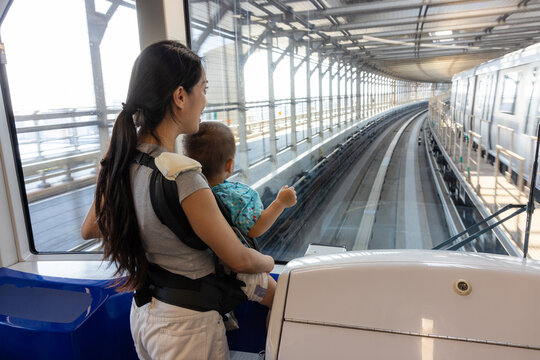 Mother carrying baby on automated train in Tokyo