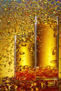 Two glasses filled with golden liquid and softgels with a sparkling golden background.