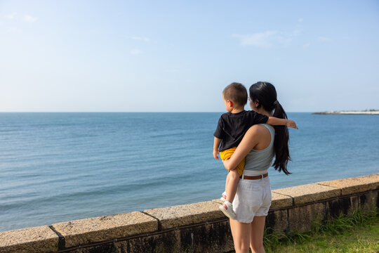 Mother holding son looking at sea in taiwan