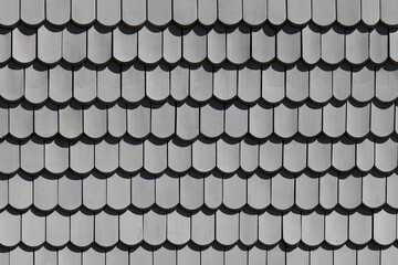 background of wooden grey shingles in harmonic structure at a farm house in grazing light © travelview