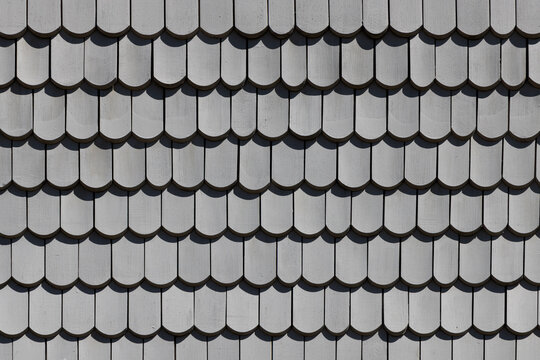 background of wooden grey shingles in harmonic structure at a farm house in grazing light