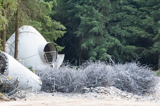 Rotor hub blade attachment point or spinner of wind turbine, dismantled tower sections, large pile of reinforcing steel, decommissioning or repowering of energy farm