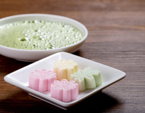 Japanese wagashi flower shaped sweets with a bowl of matcha green tea