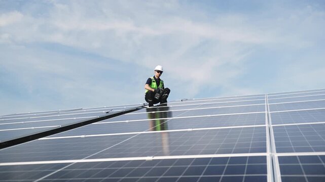 Technician installing rooftop solar panels for green energy, supporting renewable energy, clean power, sustainable technology and solar infrastructure.
