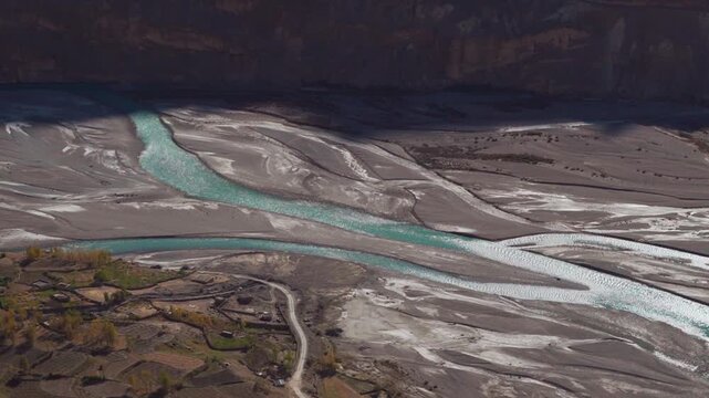 Turquoise blue Spiti river flowing through mountain valley in Spiti Valley, Himachal Pradesh, India. Small river tributaries flowing on riverbed during summer season in Himalayas. Nature background.