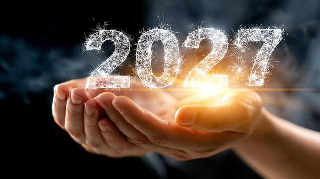Glowing 2027 new year concept floating in human hands with sparkling