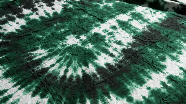 Tilted angle green black and white tie dye fabric background with layered patterns fading into textile showing slow waving motion