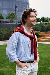 Obraz premium Stylish man with curly hair and elegant attire enjoying a sunny day outdoors