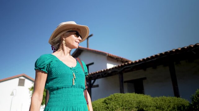 Happy woman walks around San Francisco Solano de Sonoma and enjoys the historic site on a sunny day in California.