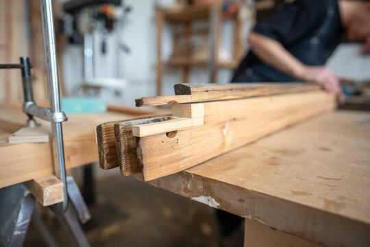 Process of selection wooden patch on window frame, preparatory work in restoration studio, professional craftsman choosing part of wood grain similar type and hardness for quality reconstruction.