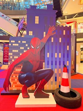 Spider-Man cardboard cutout in mall display with city backdrop