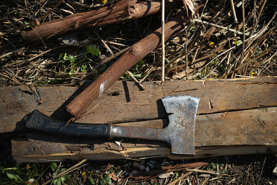 Old hand axe resting on a wooden board