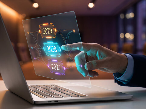 Businessman hand touching virtual screen with years 2027, 2028, and 2029 on laptop background.