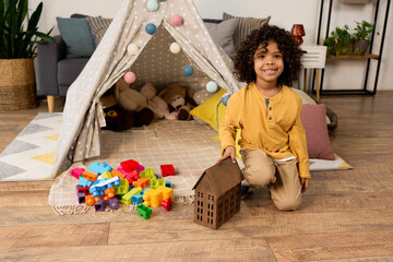 Happy moments of a young boy playing at home with colorful building blocks © LIGHTFIELD STUDIOS