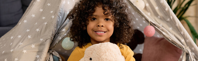 Joyful moments of a young boy playing happily at home in a cozy tent © LIGHTFIELD STUDIOS