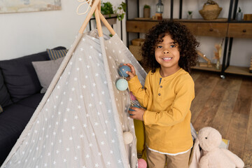 Joyful African American boy exploring at home in a cozy modern apartment © LIGHTFIELD STUDIOS