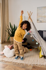Joyful moments of a young boy exploring his play tent at home © LIGHTFIELD STUDIOS