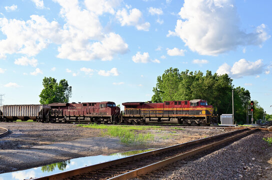Two locomotives lead a Canadian Pacific Kansas City freight train toward a rail crossing in the Chicago suburbs.