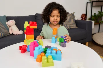 Fotobehang Lego Happy african american boy building colorful blocks at home  © LIGHTFIELD STUDIOS
