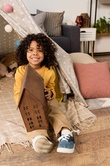 Joyful african american boy playing in a cozy modern apartment tent © LIGHTFIELD STUDIOS