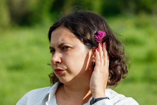 Woman with dark hair and purple flower in hair