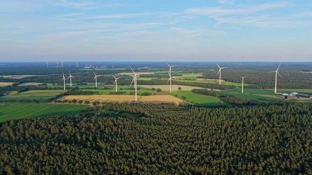 Crop cultivation. Wind turbines farm. Green energy. Wind mill for renewable electric energy production. Wind mill for renewable electric energy production. Windmill in rural area. Offshore wind park
