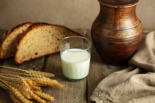 Milk homemade bread and wheat ears on vintage wood background. Copy space.