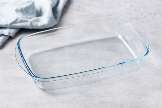 Empty ovenproof glass tray with handles on grey background ready for cooking design. Close up.