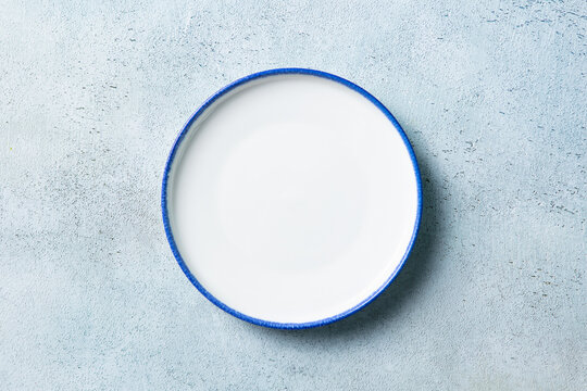 Isolated empty porcelain dish template for restaurant food placement or menu layout. Simple elegant table setting background, copy space around. Top view.