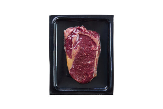 Raw beef steak in vacuum plastic packaging isolated on white background top view. Close up.