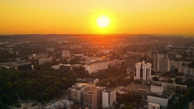 Aerial drone view of chisinau city at sunrise, moldova Buildings and green trees, yellow sky.