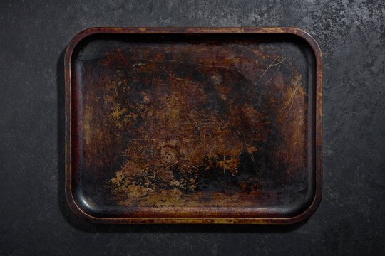 Vintage baking tray with patina and texture, dark background. Copy space, close up, top view.