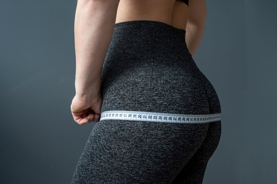 slim fitaness trainer showing her body after workouts at gym