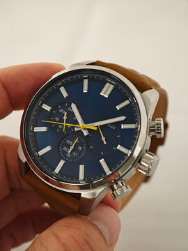 Stylish Blue Dial Watch on Male Wrist in Nature. Elegant analog wristwatch with a navy blue face and metallic silver accents
