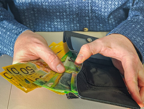 Businessman holding variety of Australian dollar banknotes 100, 50, 10 AUD for financial concept