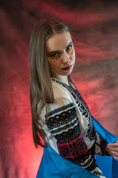 Pretty sad Ukrainian woman wear national dress clothes with flag