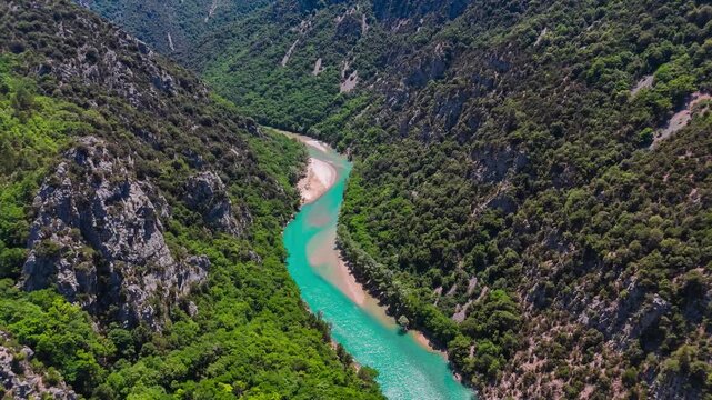 Aerial drone view of the turquoise Verdon River flowing through the Verdon Gorge river canyon in the Provence-Alpes-Cote d'Azur region of southeastern France. High quality 4k footage