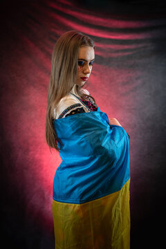 Portrait of beautiful Ukrainian woman patriot in national clothing embroidery with flag
