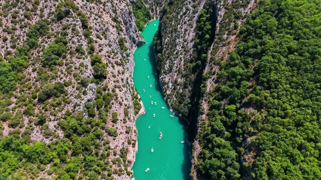 Aerial drone view of the turquoise Verdon River flowing through the Verdon Gorge river canyon in the Provence-Alpes-Cote d'Azur region of southeastern France. High quality 4k footage