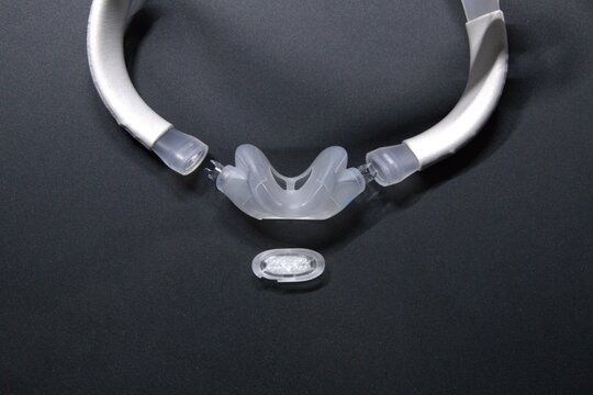 Disassembled CPAP nose mask or nasal CPAP cradle mask shows replaceable parts of CPAP headgear clip. Sleep apnea and sleep disorder with snoring stopped by respirator mask and CPAP machine treatment.