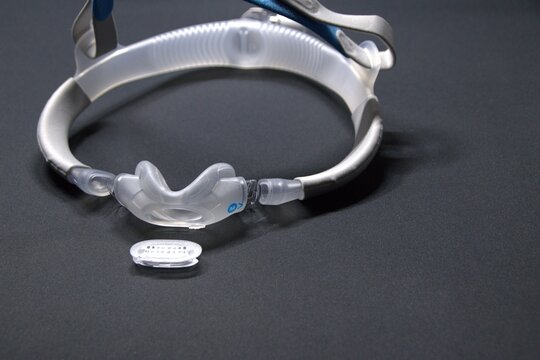 Disassembled CPAP nose mask or nasal CPAP cradle mask shows replaceable parts of CPAP headgear clip. Sleep apnea and sleep disorder with snoring stopped by respirator mask and CPAP machine treatment.