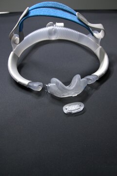 Disassembled CPAP nose mask or nasal CPAP cradle mask shows replaceable parts of CPAP headgear clip. Sleep apnea and sleep disorder with snoring stopped by respirator mask and CPAP machine treatment.