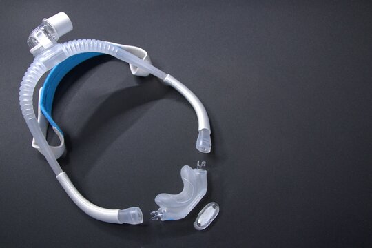 Disassembled CPAP nose mask or nasal CPAP cradle mask shows replaceable parts of CPAP headgear clip. Sleep apnea and sleep disorder with snoring stopped by respirator mask and CPAP machine treatment.