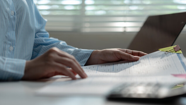 Businesswoman calculating payroll and financial reports with calculator, analyzing banking transactions, budget management, accounting, currency and business finance.
