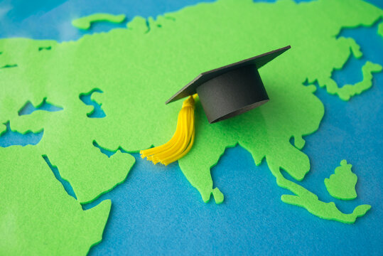 Mortarboard on world map background. Education, studying abroad program for short time or full degree, learn a foreign language summer program, e-learning online, exchange student concept.